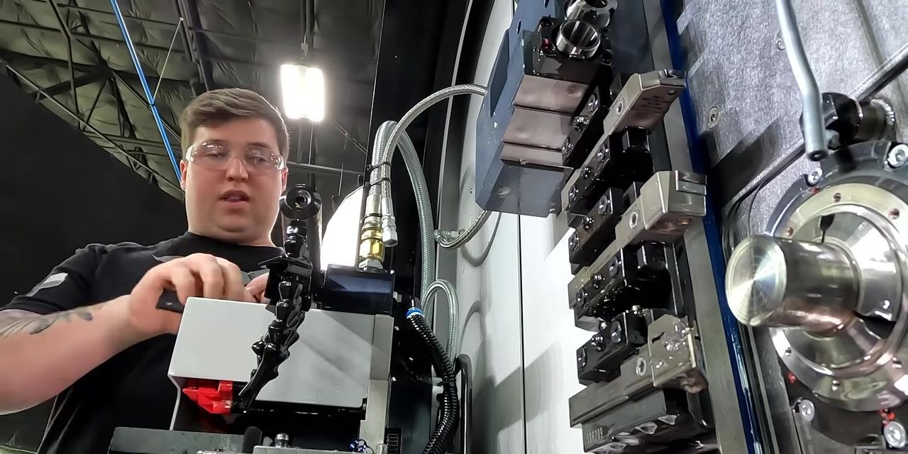 CNC machine at rest after completing the last part, with tool holders and a monitoring camera visible