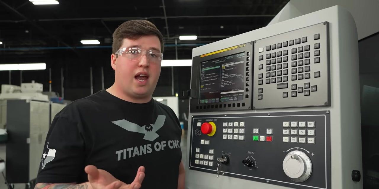 Operator explaining the benefits of programmatic messages for tool changes at CNC control panel