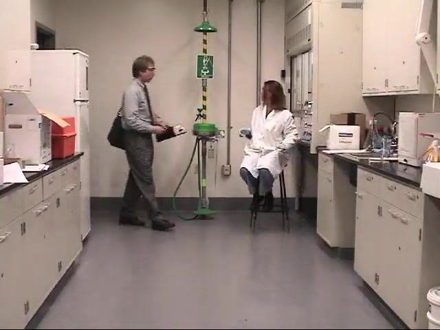 An EH&S staff member and a laboratory worker use a mercury vapor detector to check the floor and cabinet area for contamination.