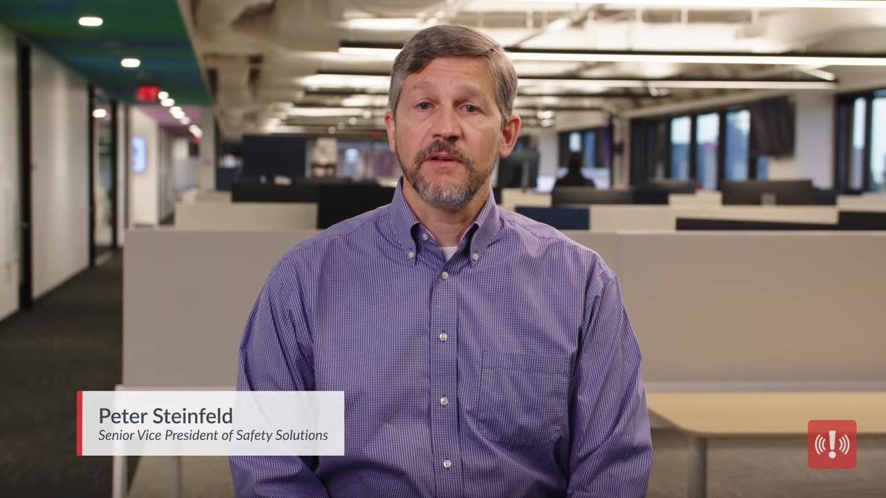 Presenter Peter Steinfeld, labeled as Senior Vice President of Safety Solutions, sitting in a modern office environment.