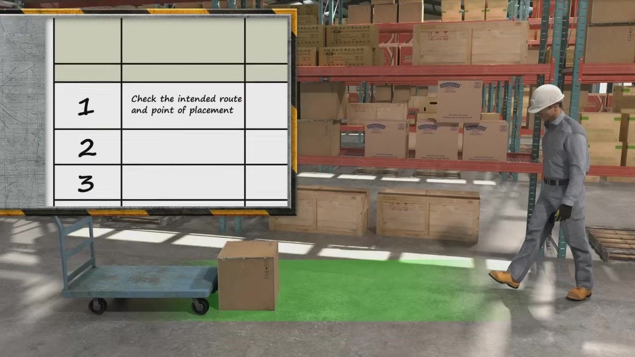 A worker in a warehouse bending down to lift a heavy box near a cart, demonstrating the observation phase of a JHA