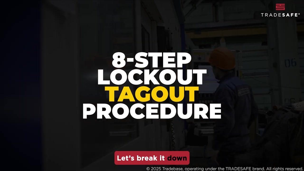 Two workers in safety vests and hard hats discuss procedures in front of industrial machinery.
