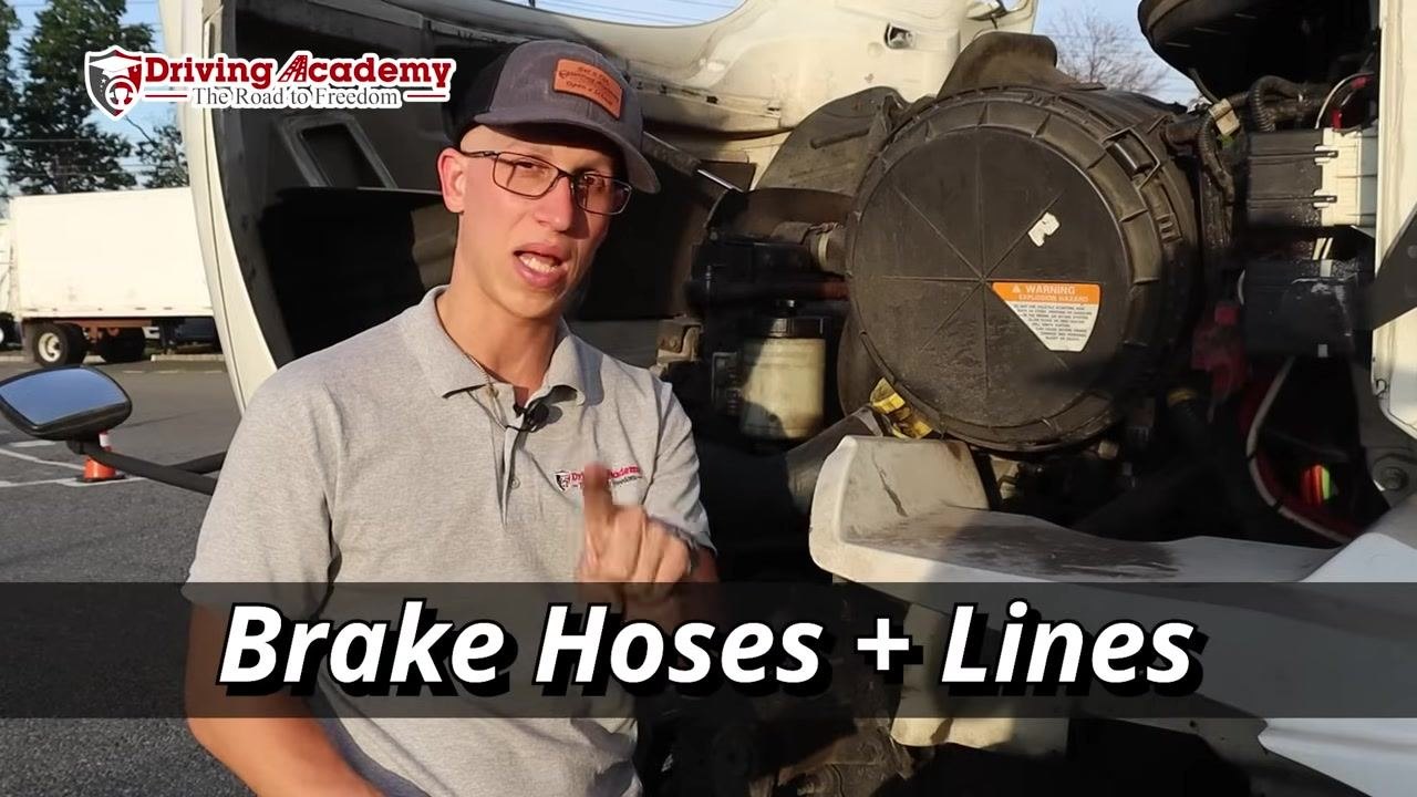 Instructor closely examining and pointing at individual lug nuts on the wheel.