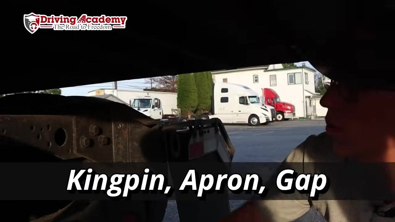 Close-up under the trailer showing the kingpin, apron, and the gap between them.