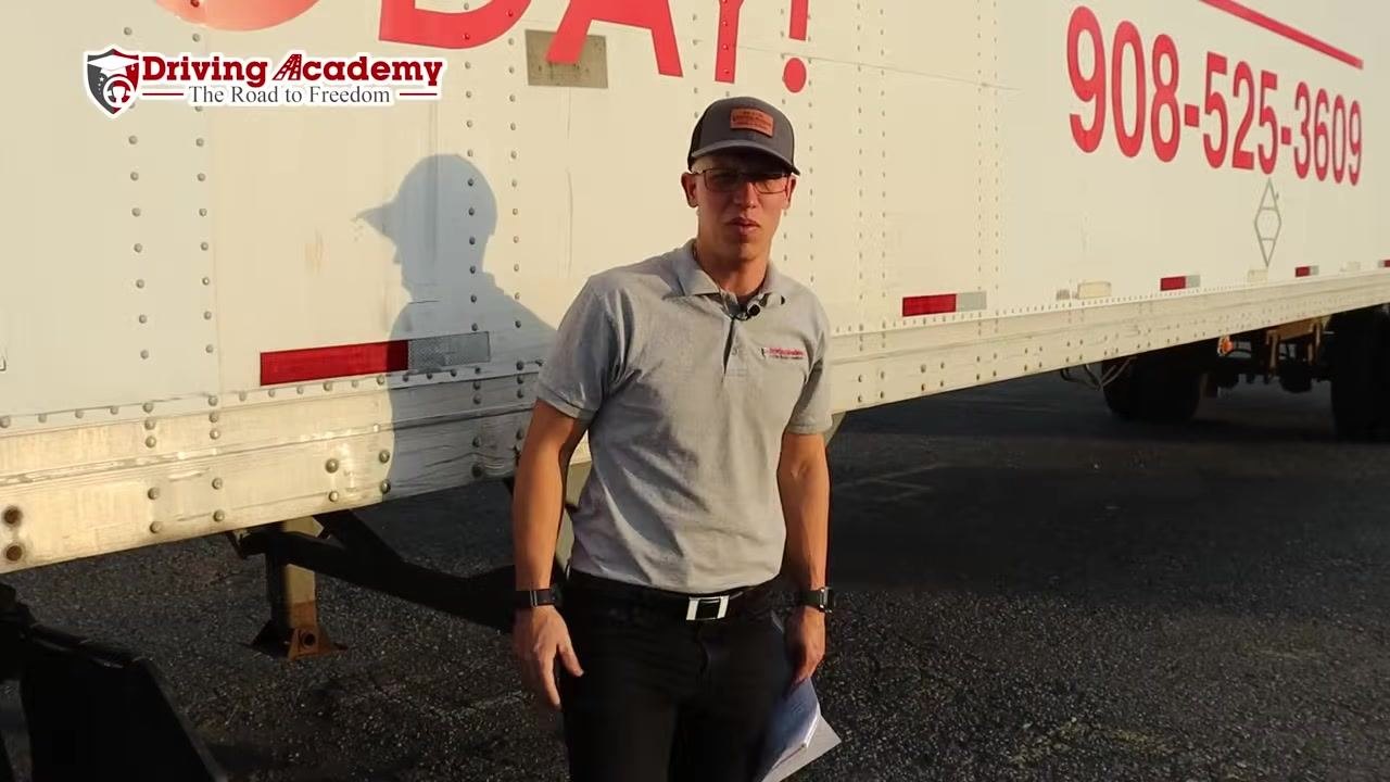 Instructor standing beside the trailer after completing the fifth wheel inspection.