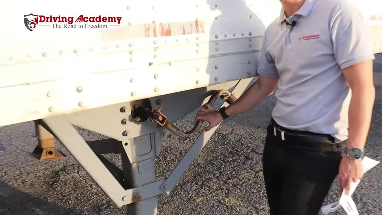 Instructor holding the landing gear crank handle to demonstrate clearance between the landing gear and the axle.