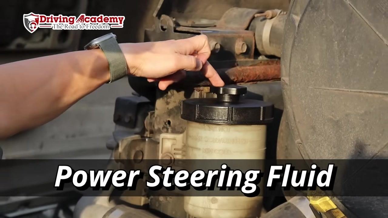 Instructor unscrewing the power steering fluid reservoir cap.