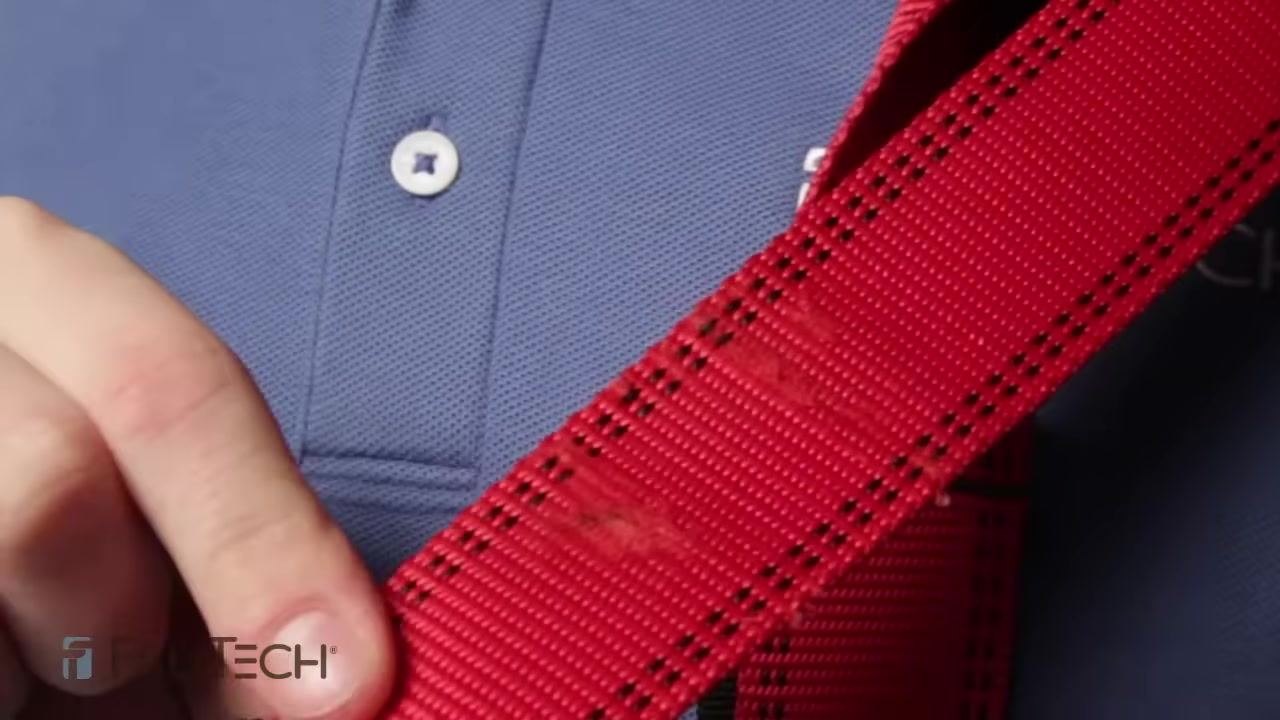 Close-up of red harness webbing showing visible wear and thinning, indicating possible fall damage