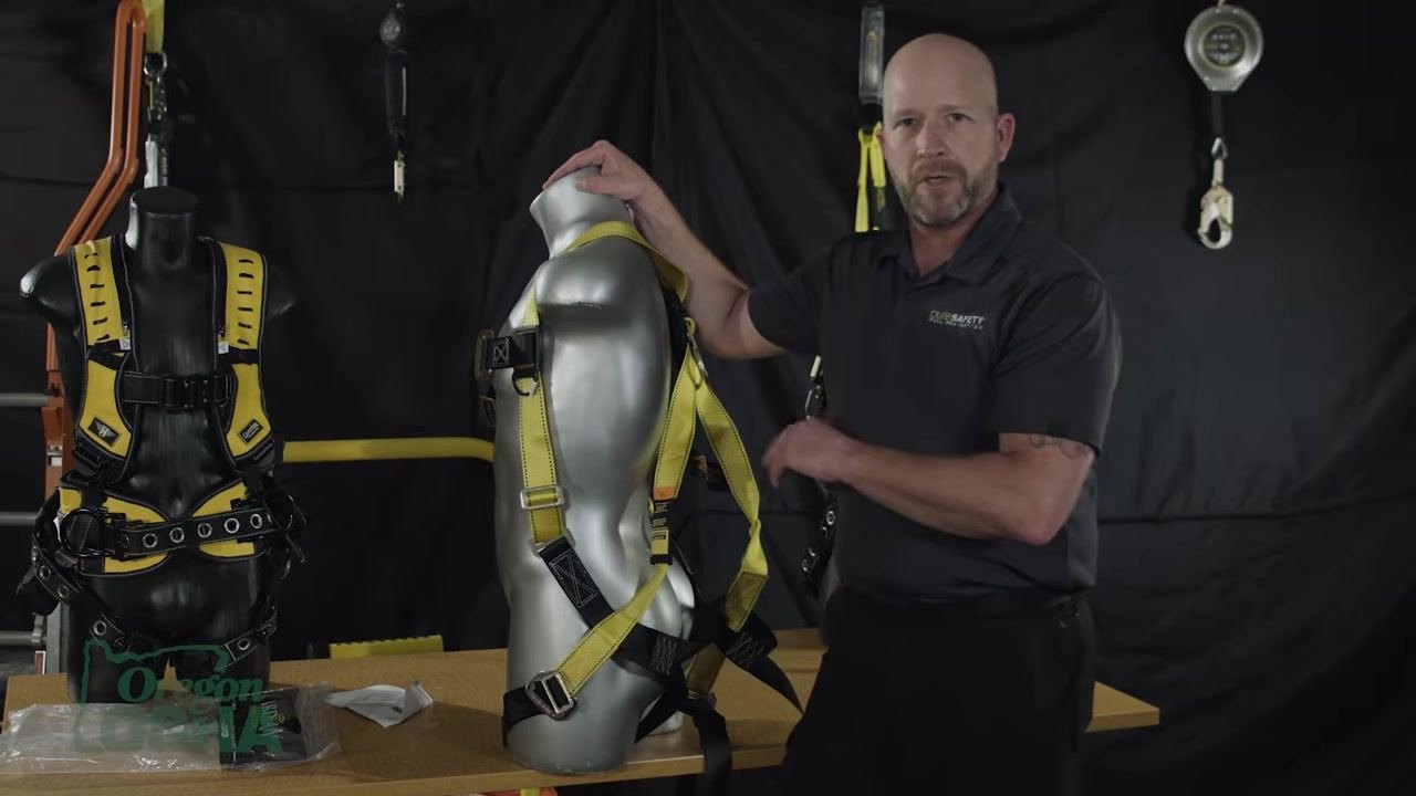 Gesturing to the harness on a mannequin, explaining the process of making even adjustments