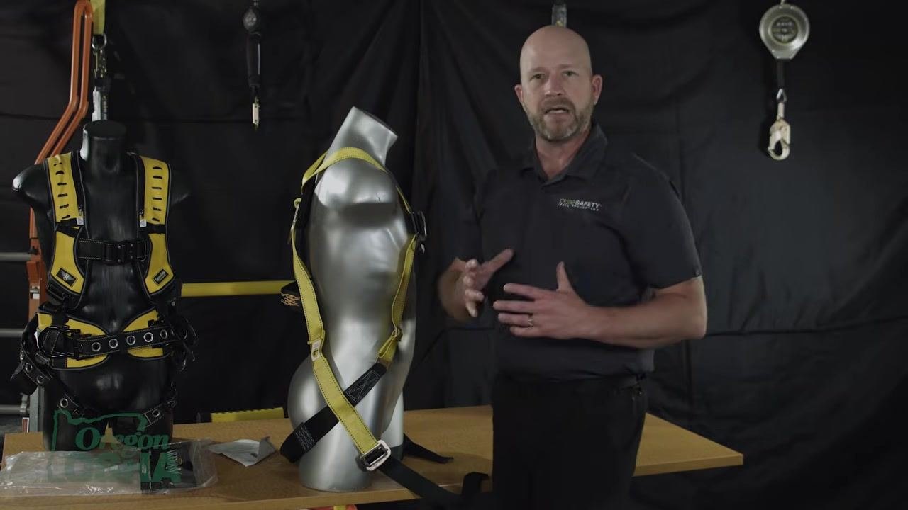 Gesturing with hands in front of a harnessed mannequin, explaining force distribution