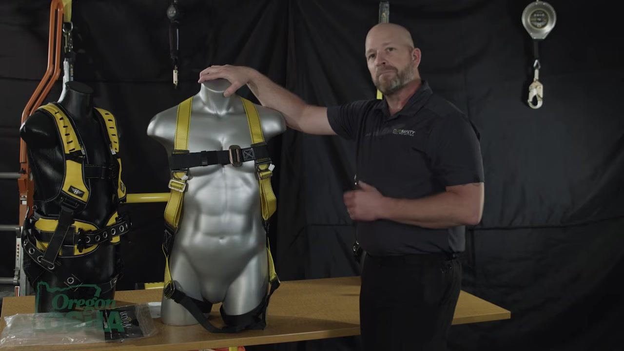 A hand placed on the mannequin's shoulder, indicating the harness is properly adjusted and fitted