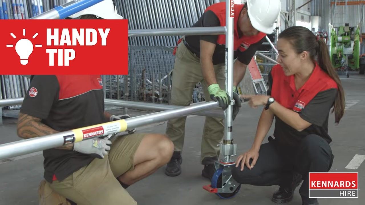 Worker securing the upper frame of the scaffold and locking the frame clips