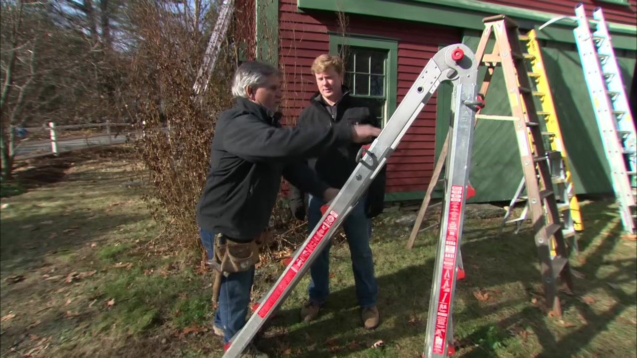 One person adjusts a multi-position ladder while another observes, with other ladders visible in the background.