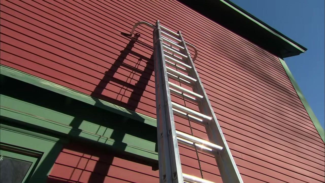 A close-up shows a person pointing to the top cap and upper steps of a step ladder to indicate the areas where you should not stand.