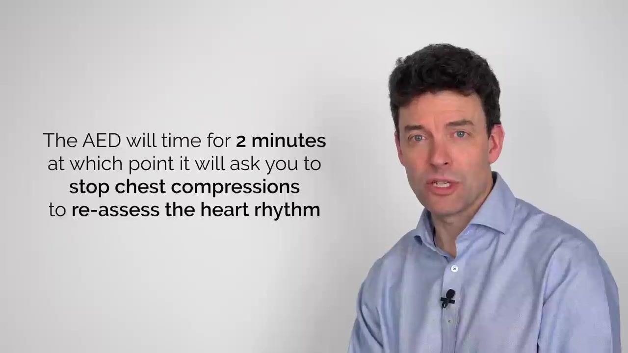 On-screen text: "The AED will time for 2 minutes at which point it will ask you to stop chest compressions to re-assess the heart rhythm"