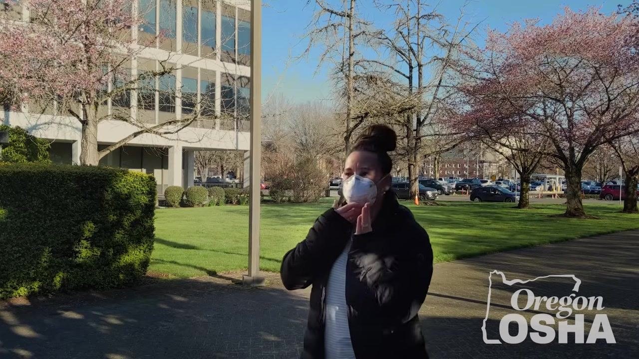 Person performing a seal check outdoors by touching the mask