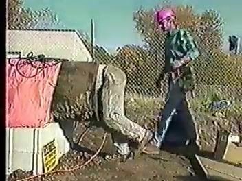 Worker climbing into a pipe while another worker stands by, both wearing hard hats and PPE.