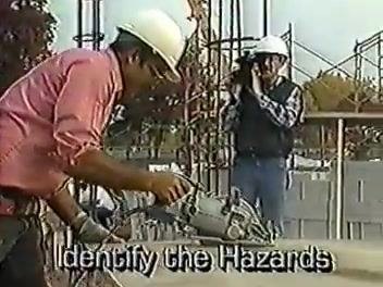 Worker using a power tool while another documents the process; on-screen text reads "Identify the Hazards."