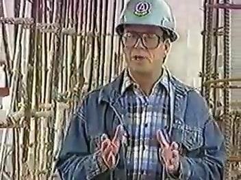 Instructor in blue hard hat and glasses gesturing with hands in front of rebar at a construction site