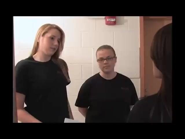 Two assistants standing inside the apartment monitoring the resident's compliance.