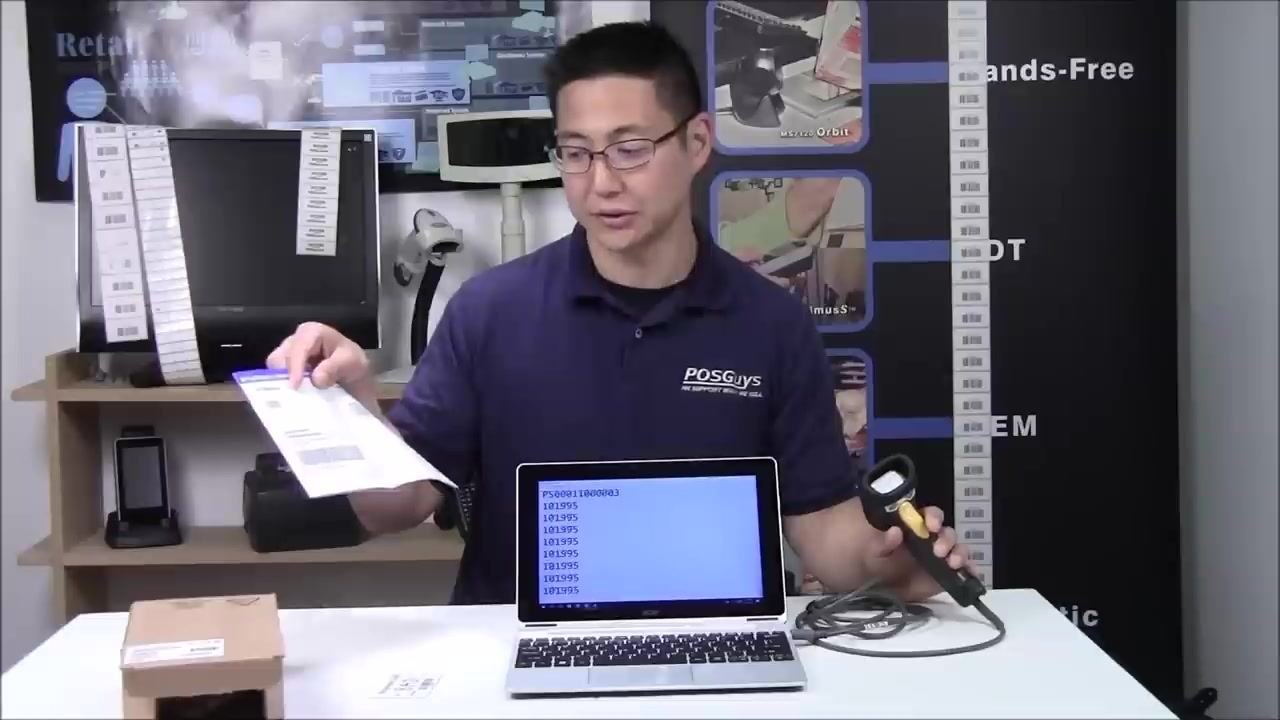 A person holding the quick start guide and the scanner, explaining how to restore default settings, with the laptop on the table showing barcode data.