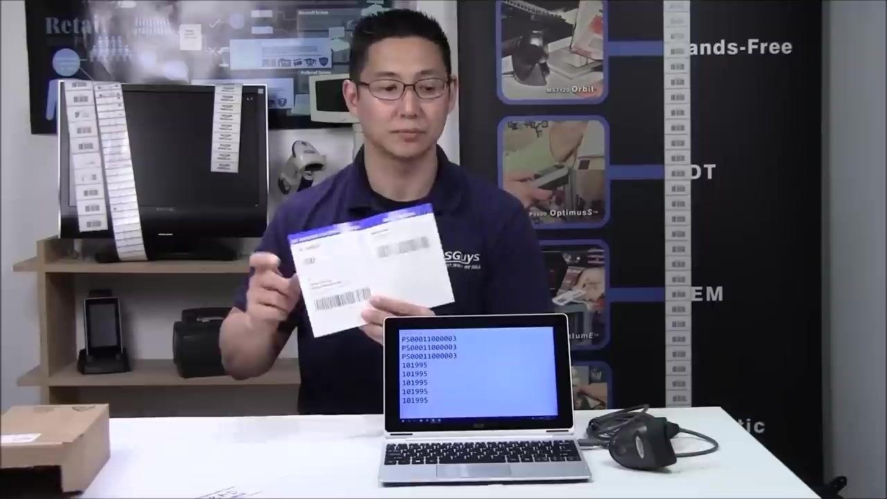A person holding the quick start guide open to display configuration barcodes, with the laptop showing scanned data in Notepad.