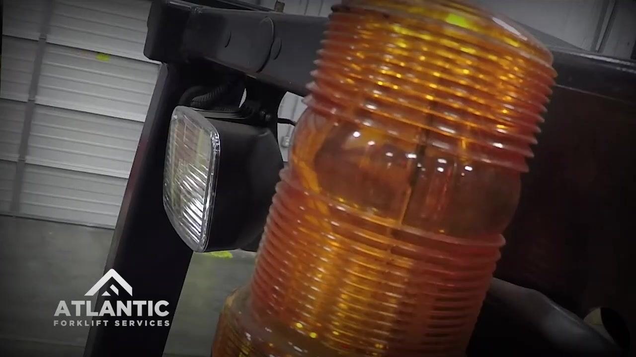 Operator actively manipulating hydraulic controls, focusing on the side shift function, with a clear view of the forklift mast and controls.