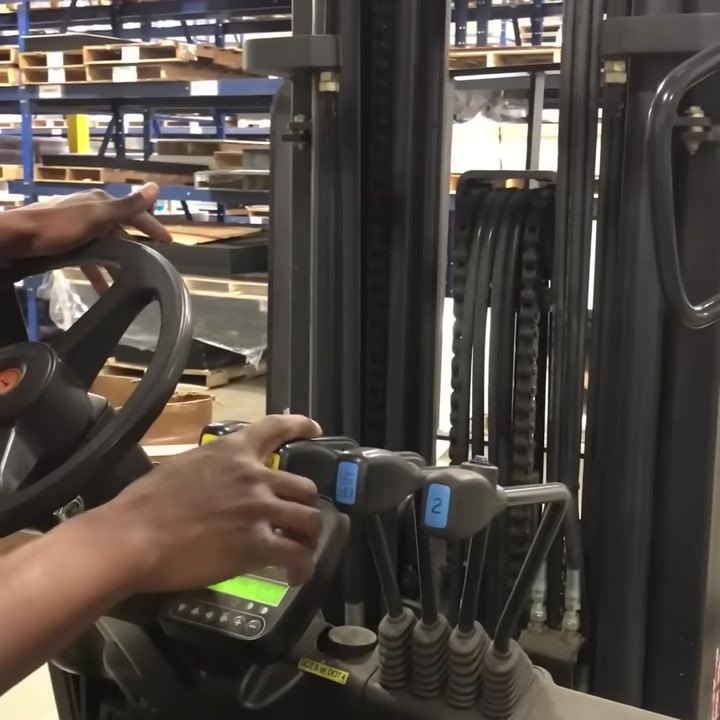 Operator pointing to hydraulic control levers, each labeled and color-coded.