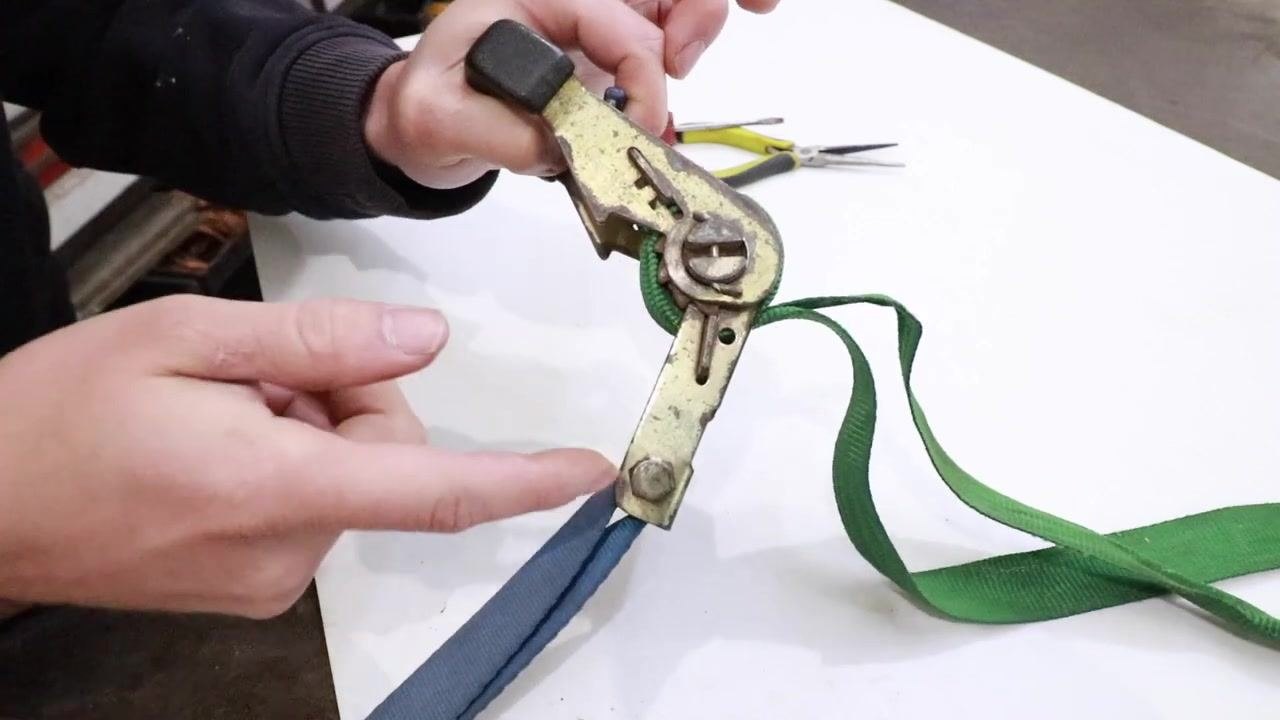 The ratchet held in one hand, with a screwdriver and needle nose pliers visible on the table.