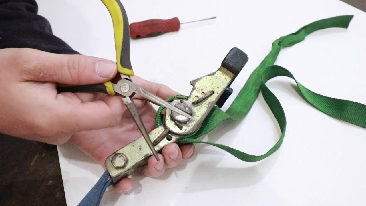 Needle nose pliers inserted into the spool slot, rotating the shaft counterclockwise.